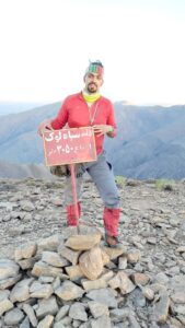 تصویر آقای فریبرزی به همراه تابلو قله سیالوک